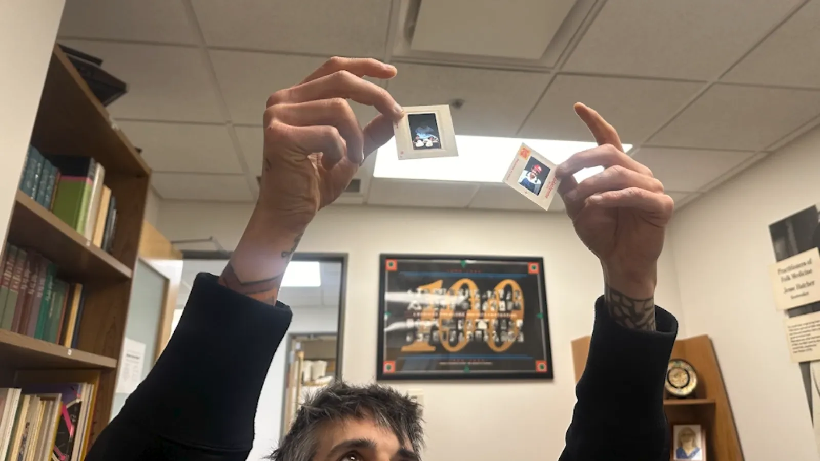 Student researcher holding slide above his head