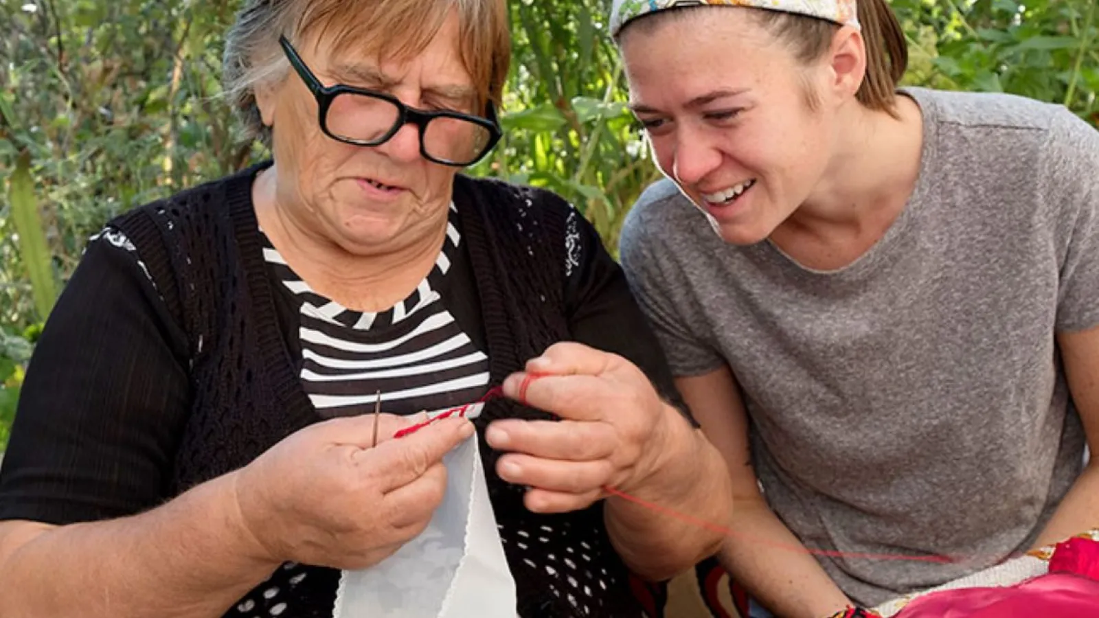 Sarah Craycraft closely watches Tsvetana Todorova working on her needlecraft in Bulgaria.