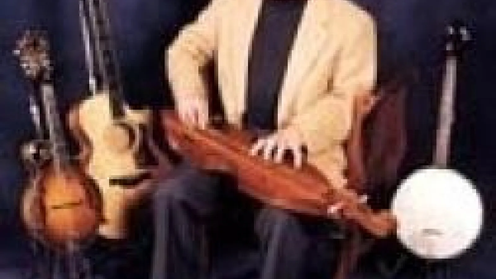 Hank Arbaugh sitting amongst five string instruments